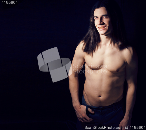 Image of handsome young man with long hair naked torso on black backgroun