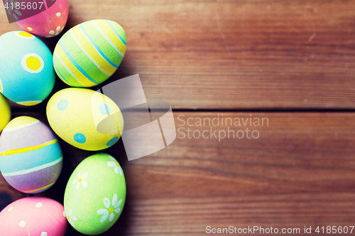 Image of close up of colored easter eggs on wooden surface