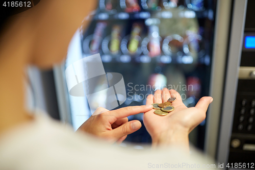 Image of woman counting euro coins at vending machine