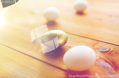 Image of close up of golden and white easter eggs on wood