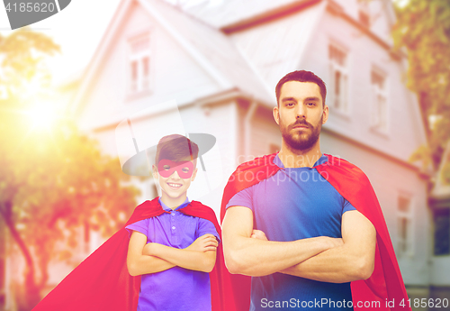 Image of man and boy wearing mask and red superhero cape