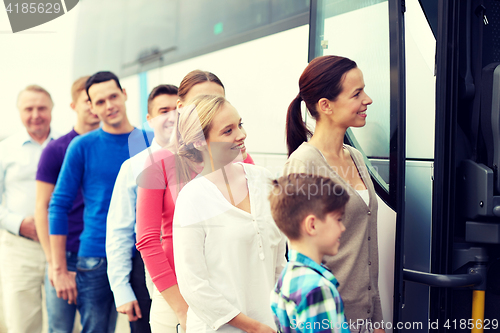 Image of group of happy passengers boarding travel bus