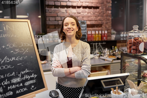 Image of happy woman or barmaid at cafe counter