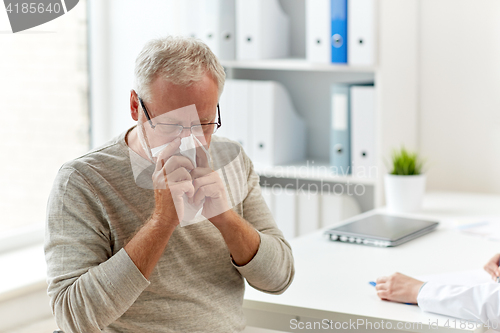 Image of senior man blowing nose with napkin at hospital