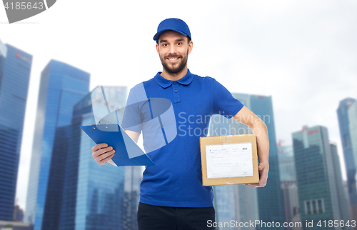 Image of happy delivery man with parcel box and clipboard