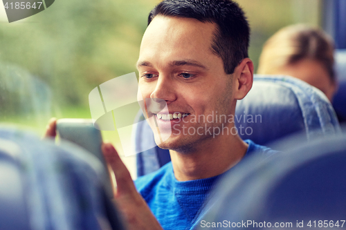 Image of happy man sitting in travel bus with smartphone