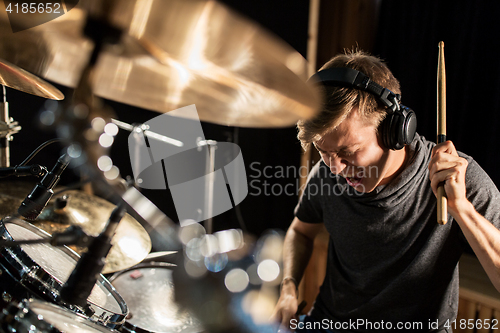 Image of male musician playing drums and cymbals at concert