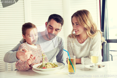 Image of happy family having dinner at restaurant or cafe