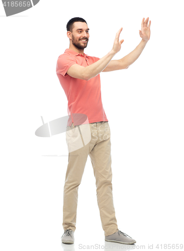 Image of happy man touching something imaginary