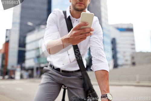 Image of man with smartphone and fixed gear bike on street