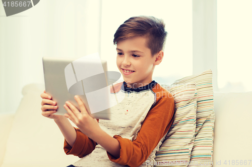 Image of smiling boy with tablet computer at home