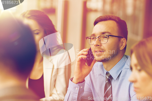 Image of businessman calling on smartphone at office