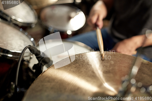 Image of male musician playing drums and cymbals at concert