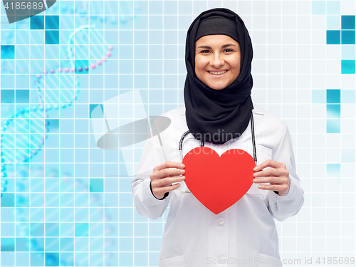 Image of muslim female doctor in hijab holding red heart