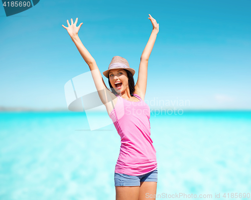 Image of happy young woman in hat on summer beach