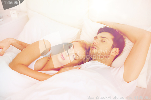 Image of happy couple sleeping in bed at home