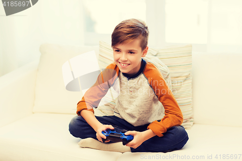 Image of happy boy with joystick playing video game at home