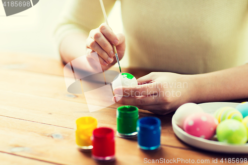 Image of close up of woman hands coloring easter eggs