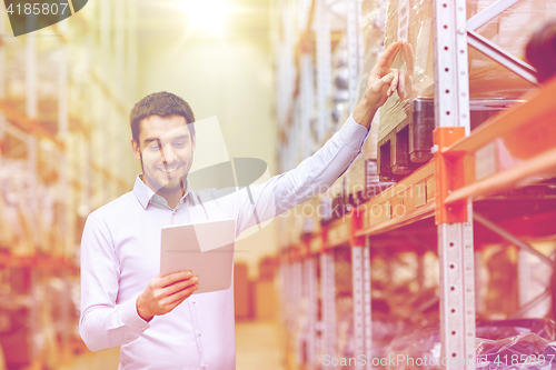 Image of happy businessman with tablet pc at warehouse