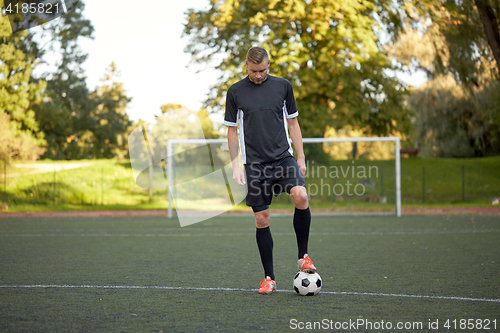 Image of soccer player playing with ball on football field