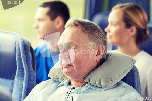 Image of senior man sleeping in travel bus with neck pillow