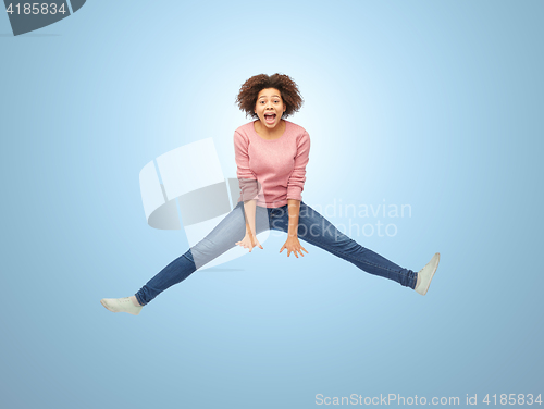 Image of happy african american woman jumping over white