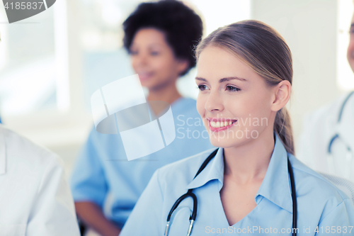 Image of happy doctor over group of medics at hospital