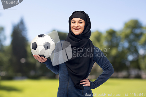 Image of happy muslim woman in hijab with football