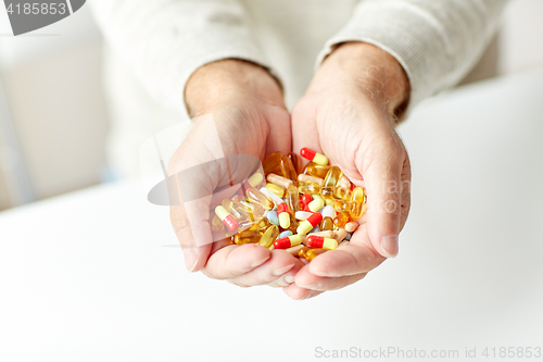 Image of close up of senior man hands holding pills