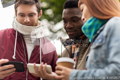 Image of happy friends with smartphone and coffee outdoors