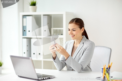 Image of businesswoman with smartphone at office