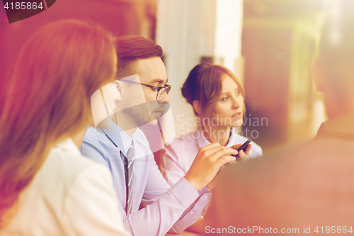 Image of businessman texting on smartphone at office