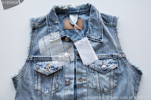 Image of close up of denim waistcoat with price tag