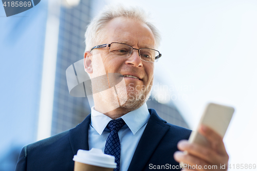 Image of businessman with smartphone and coffee in city