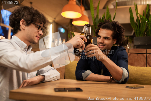 Image of happy male friends drinking beer at bar or pub