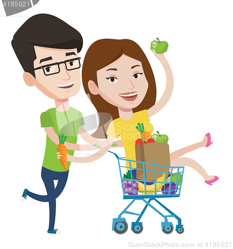 Image of Couple of friends riding in shopping trolley.