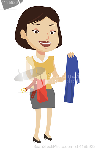 Image of Young woman choosing clothes in shop.