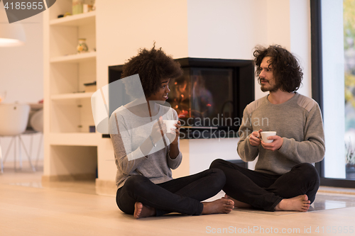 Image of multiethnic couple  in front of fireplace