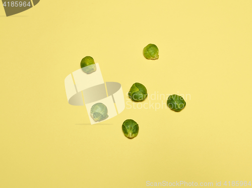 Image of The piles of Brussels sprouts on a yellow background