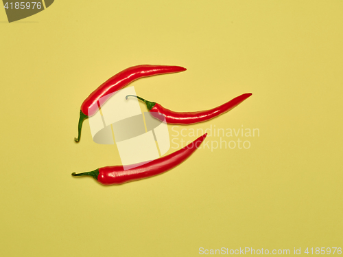 Image of bitter chili pepper and paprika on a yellow background
