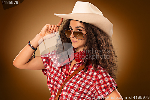 Image of The cowgirl fashion woman over a brown background