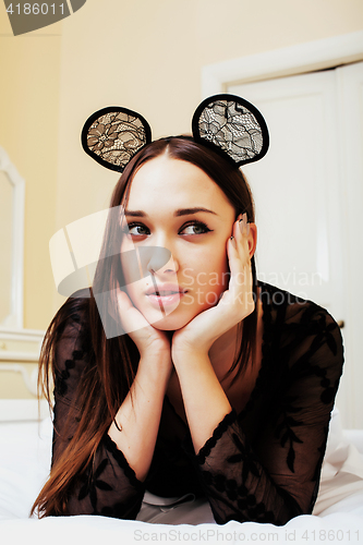 Image of young pretty brunette woman wearing sexy lace mouse ears, laying