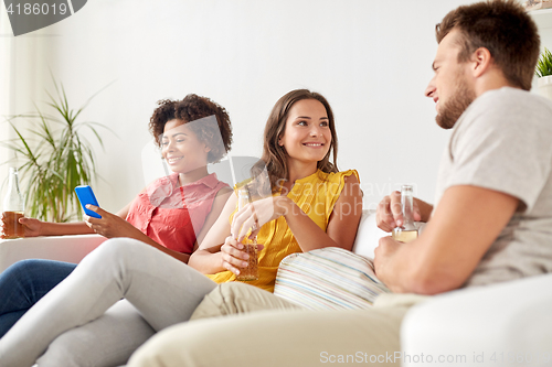 Image of group of happy friends with beer talking at home