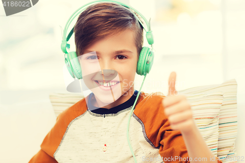Image of happy boy in headphones showing thumbs up at home