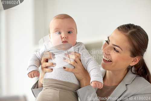 Image of happy businesswoman with baby at office