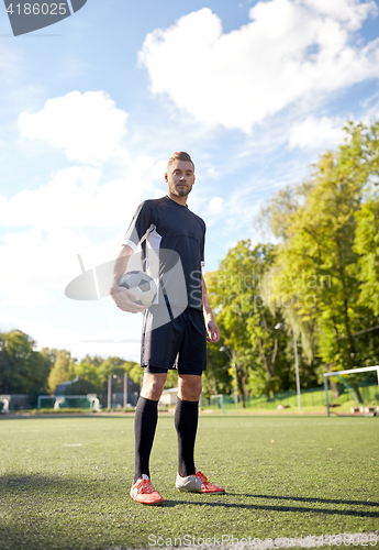 Image of soccer player with ball on football field