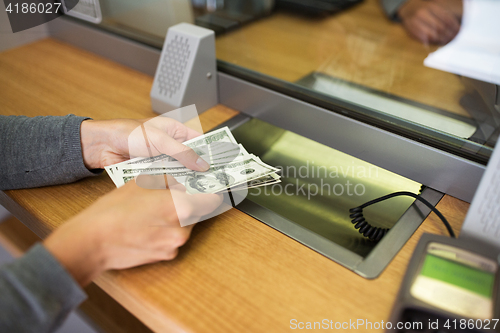 Image of hands with money at bank or currency exchanger