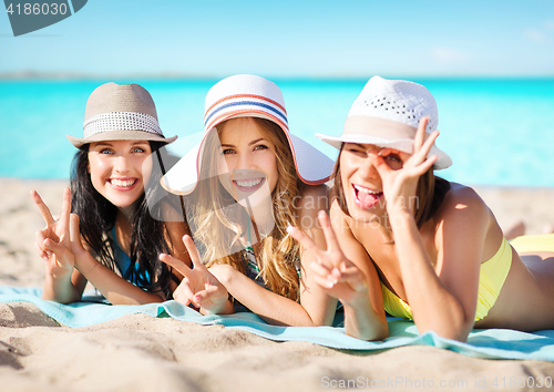 Image of happy young women in bikinis on summer beach