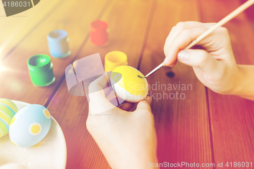 Image of close up of woman hands coloring easter eggs