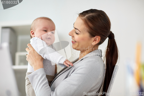 Image of happy businesswoman with baby at office